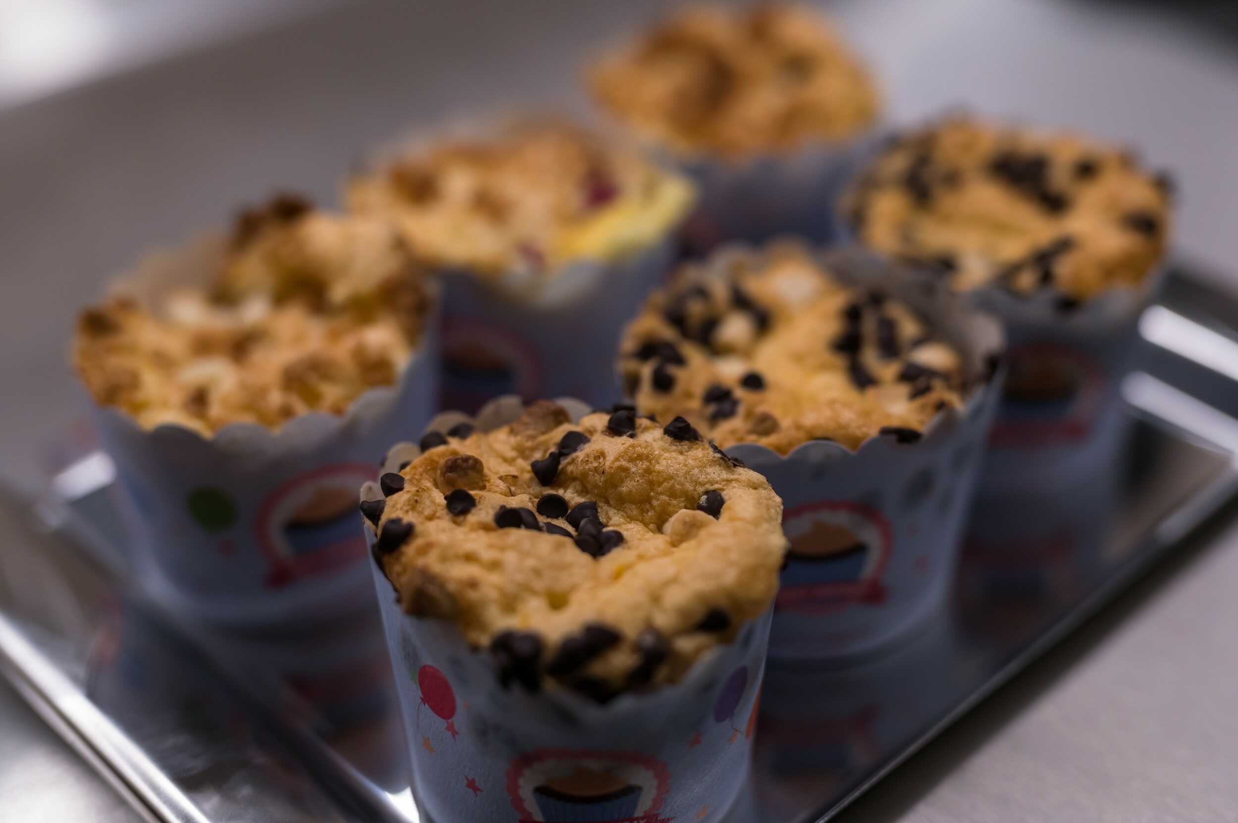 Detail čerstvě upečených domácích borůvkových muffinů s drobenkou připravených k podávání.