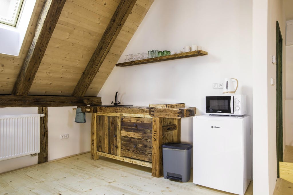 Kuchyňská linka z masivního dřeva s lednicí a mikrovlnnou troubou v podkrovním Apartmánu 2.