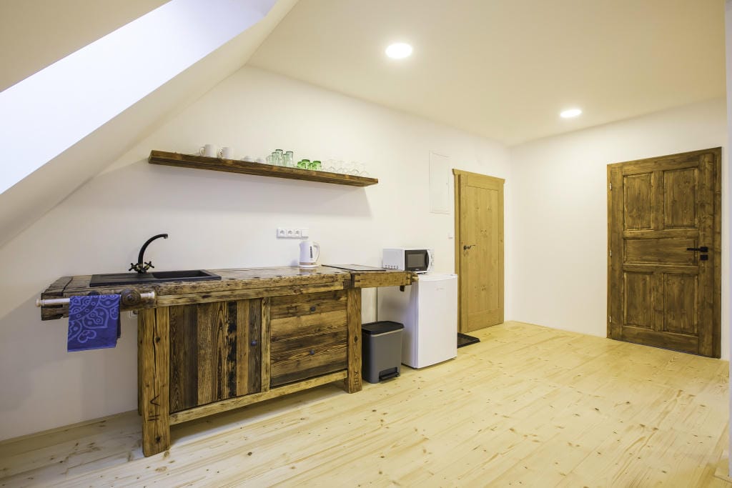 Kuchyňská linka v rustikálním designu z recyklovaného dřeva s moderními spotřebiči v Apartmánu 3 - Akce v Třeboni.